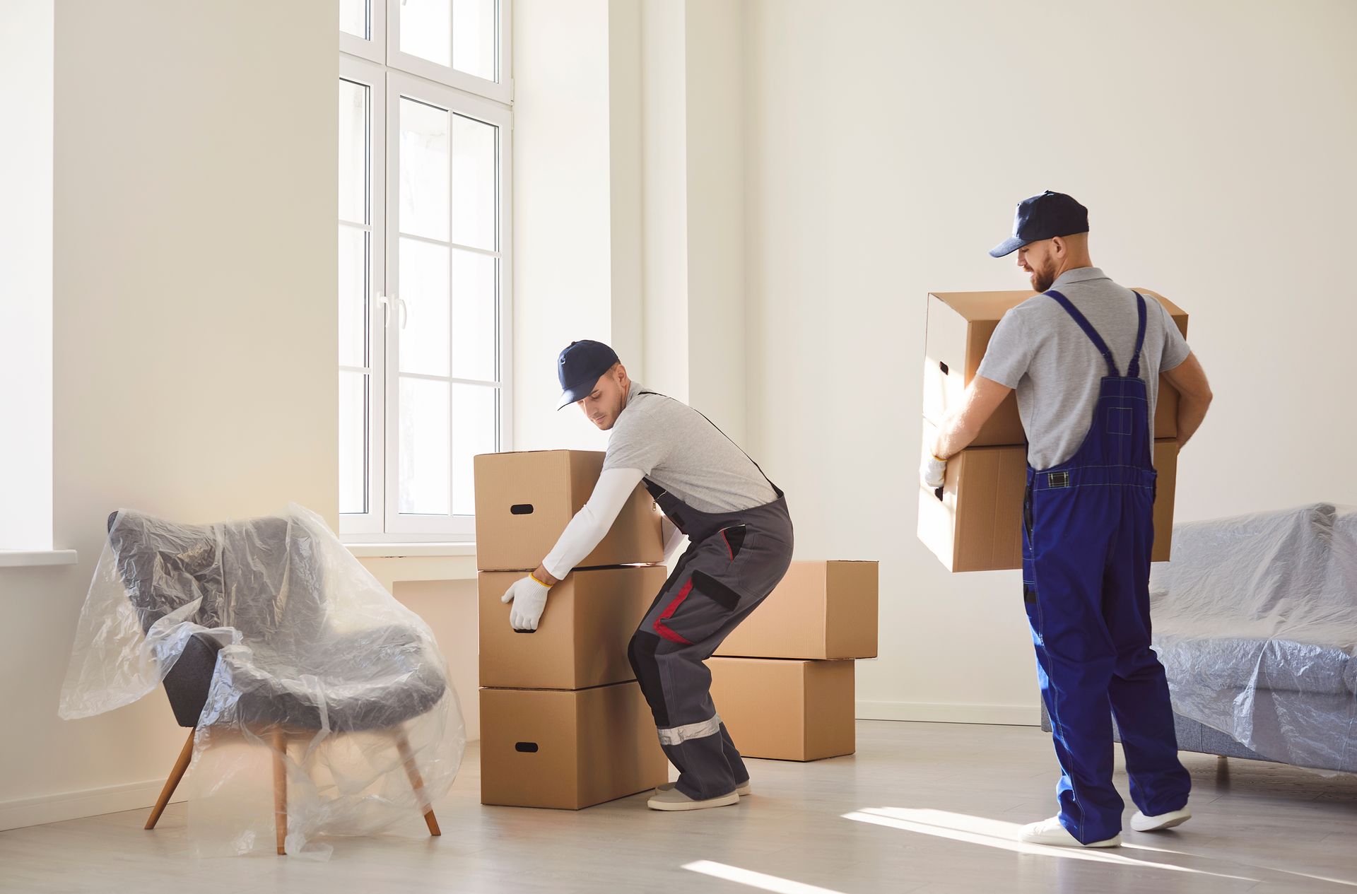 Two men are loading boxes into a moving truck.