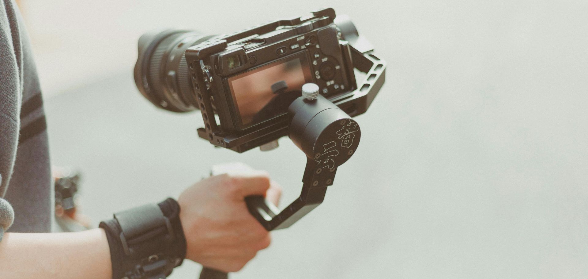 männliche Hand hält Gimbal mit Kamera
