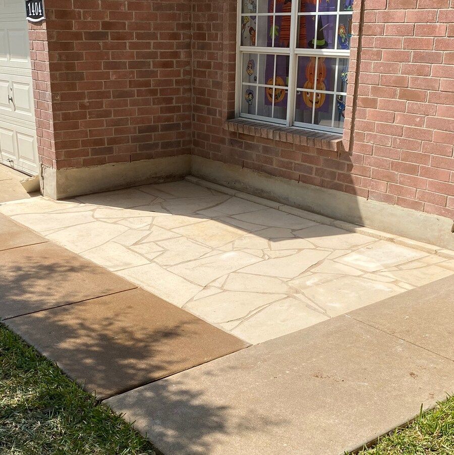 A brick house with a concrete walkway in front of it