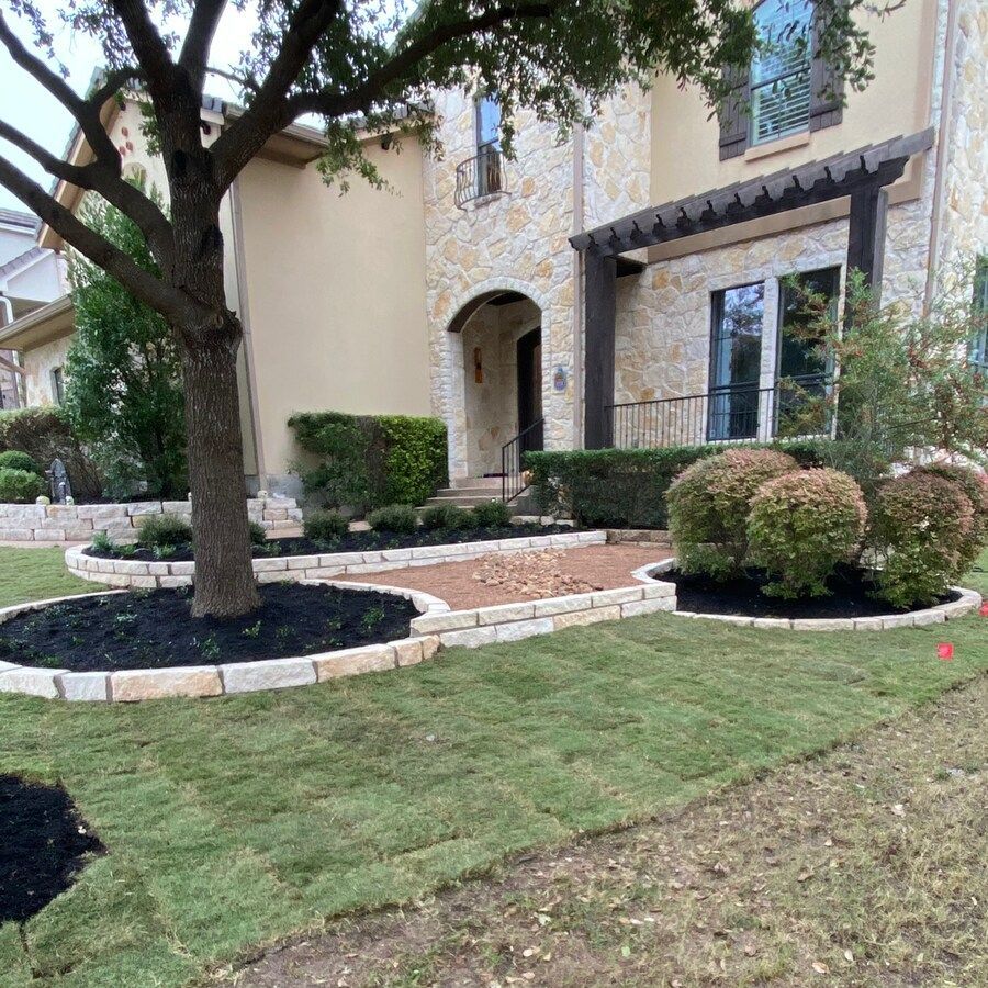 A large house with a lush green lawn and a tree in front of it.
