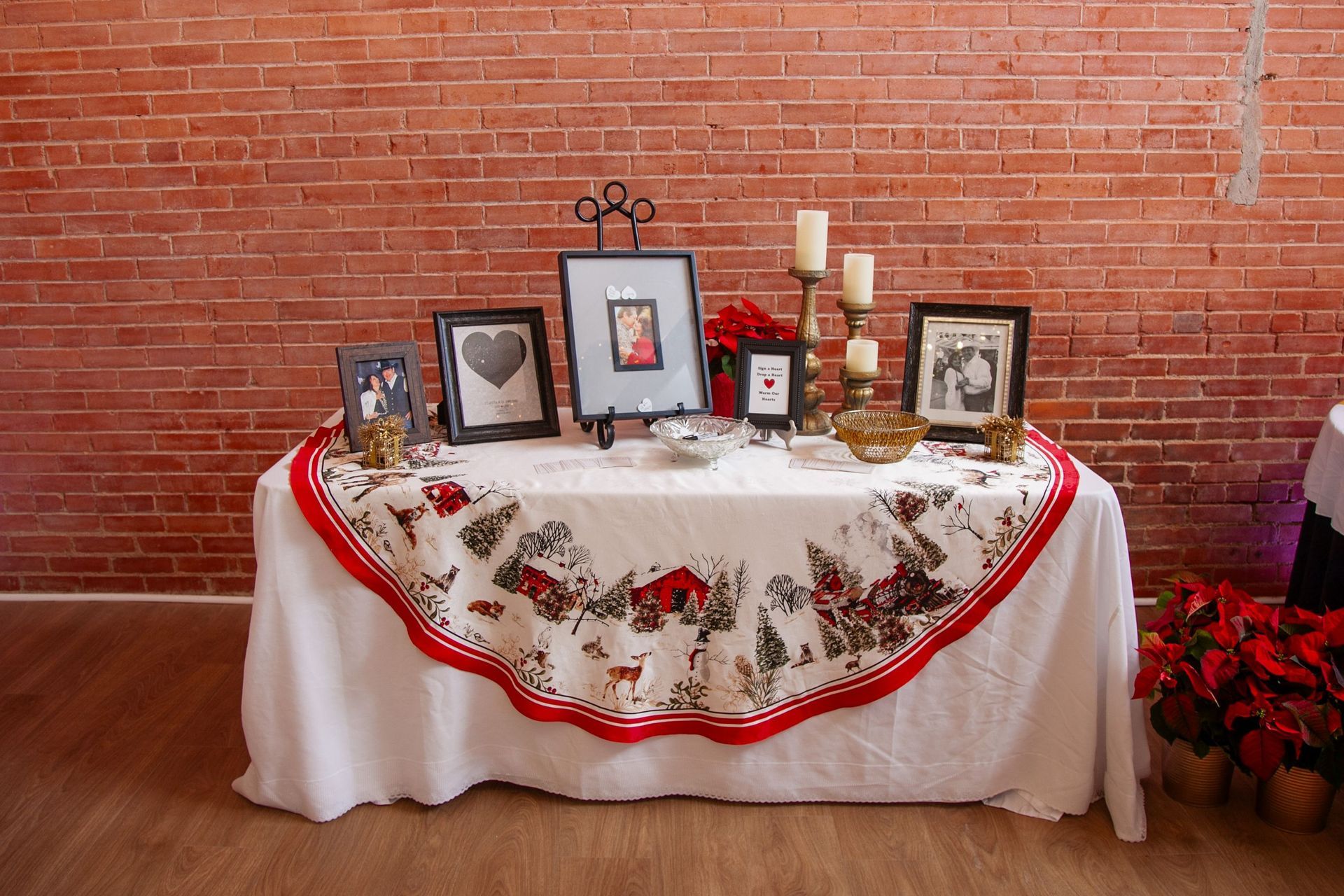 a table with pictures and candles on it in front of a brick wall .