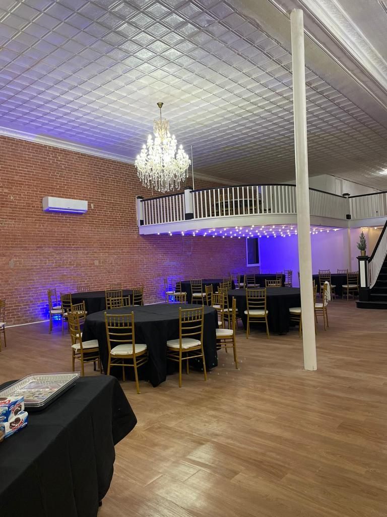 a large room with tables and chairs and a chandelier .