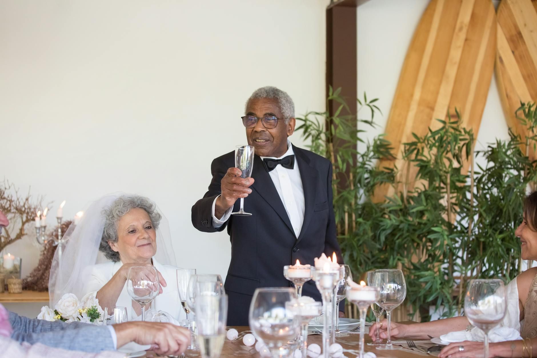 A groom encouraging a toast in front of their guests that's enjoying the beverages in their wedding.