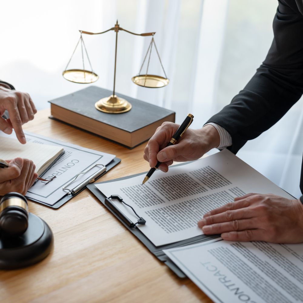 A man is writing on a piece of paper in front of a judge 's gavel.