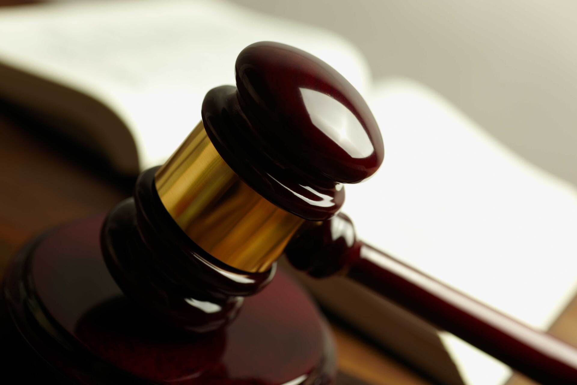 A close up of a judge 's gavel with a book in the background