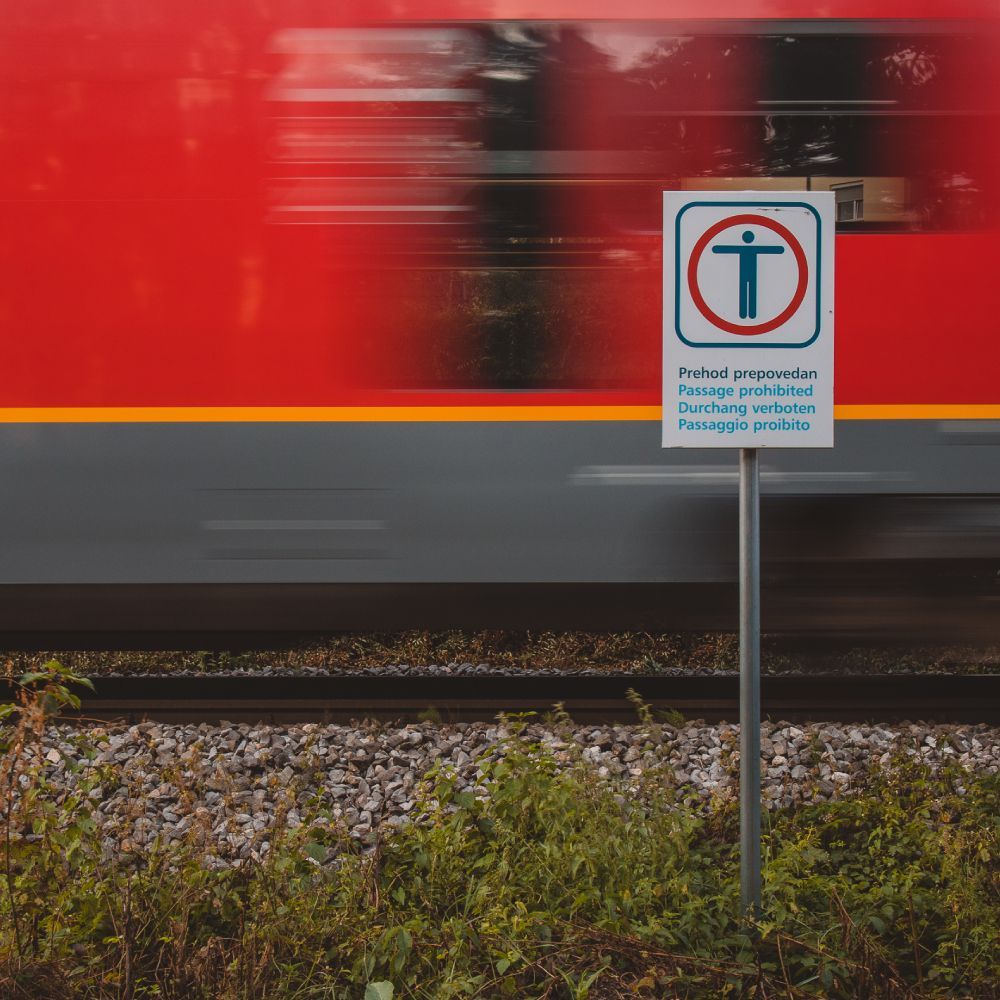 A train is passing by a sign that says no parking