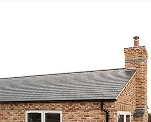 a brick house with a chimney on top of it .