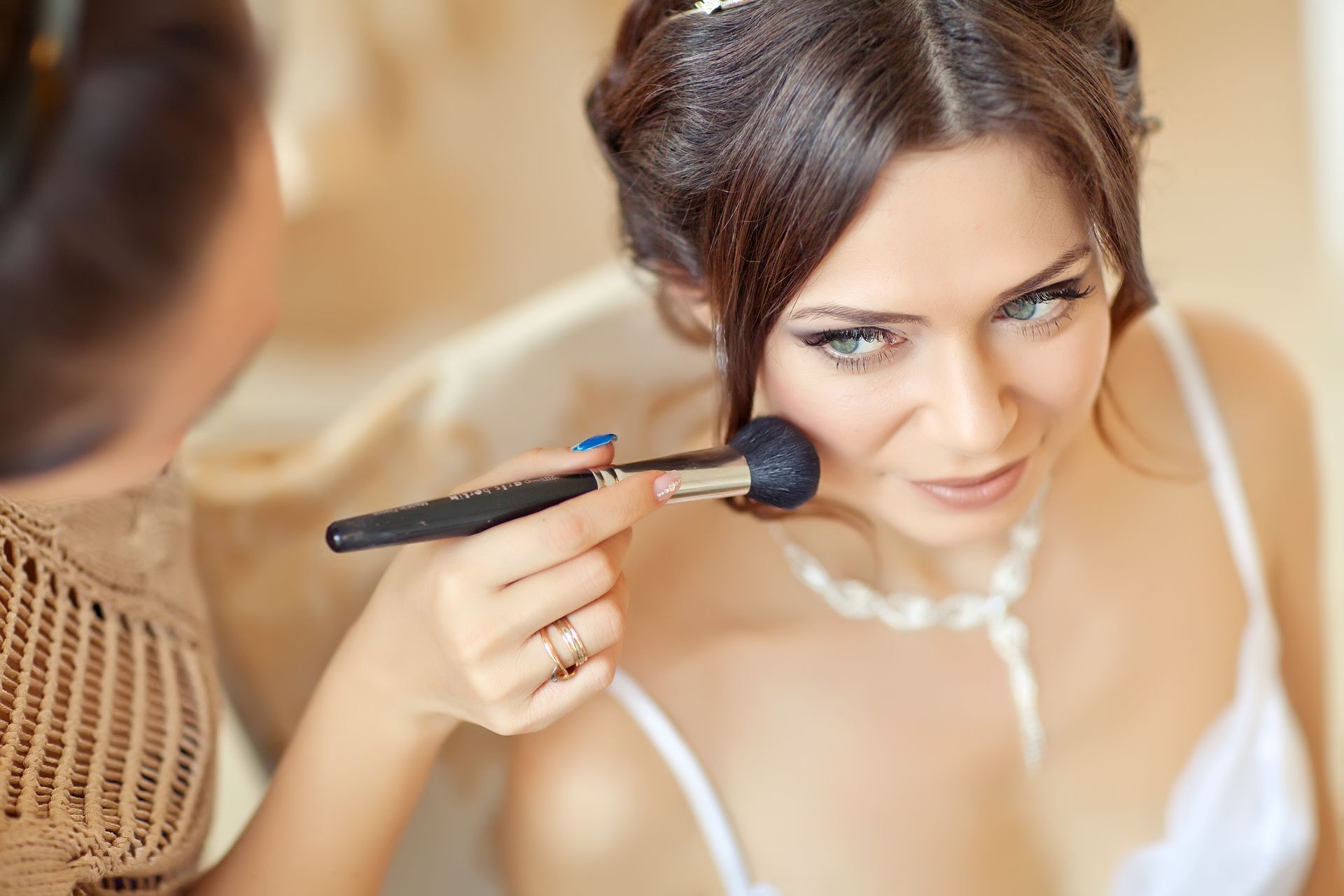 Woman getting makeup applied with brush