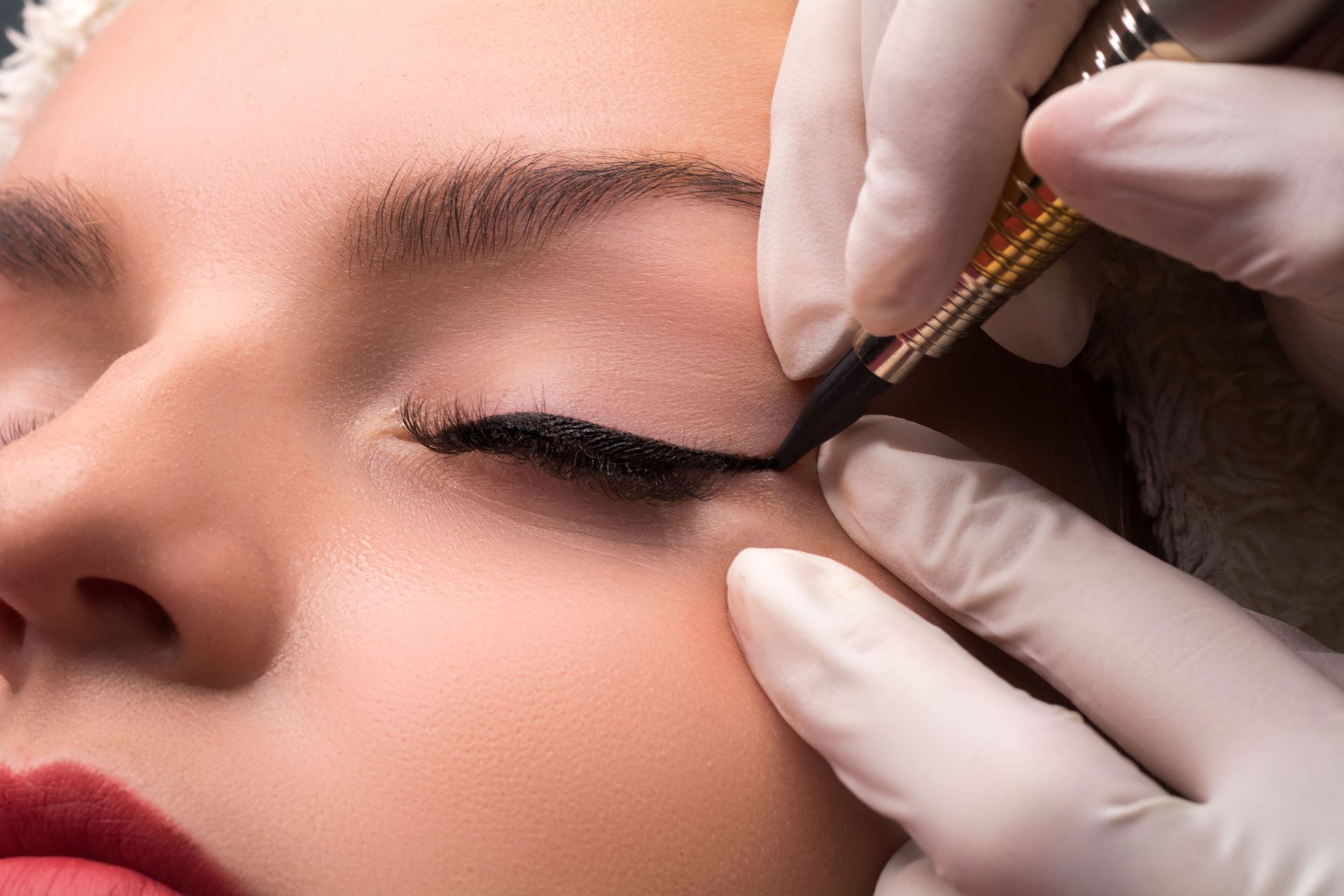 Close-up of a person getting permanent eyeliner applied