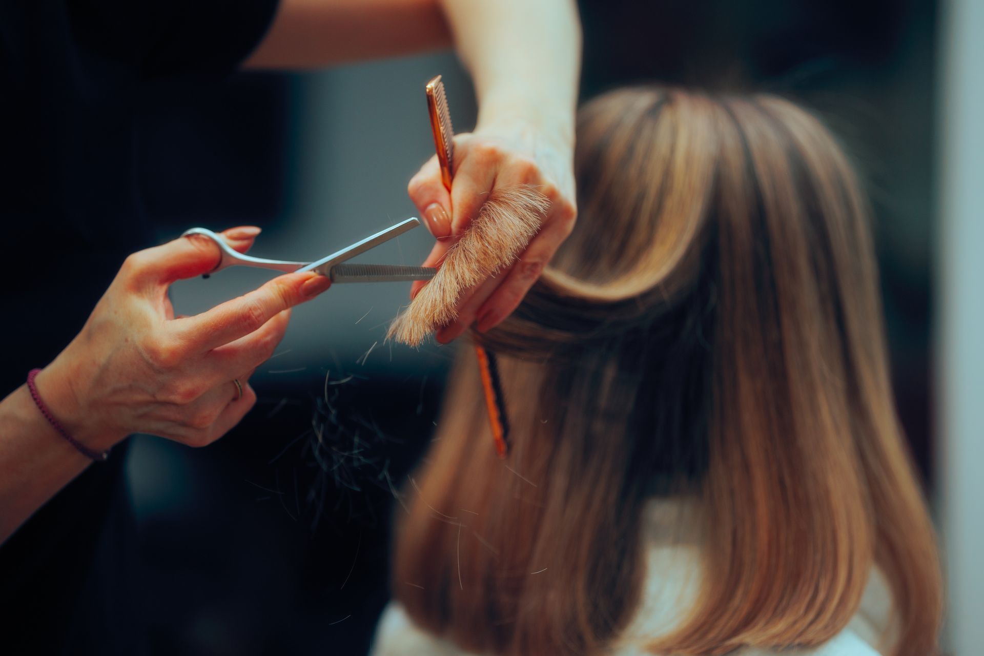 Hands cutting hair with scissors