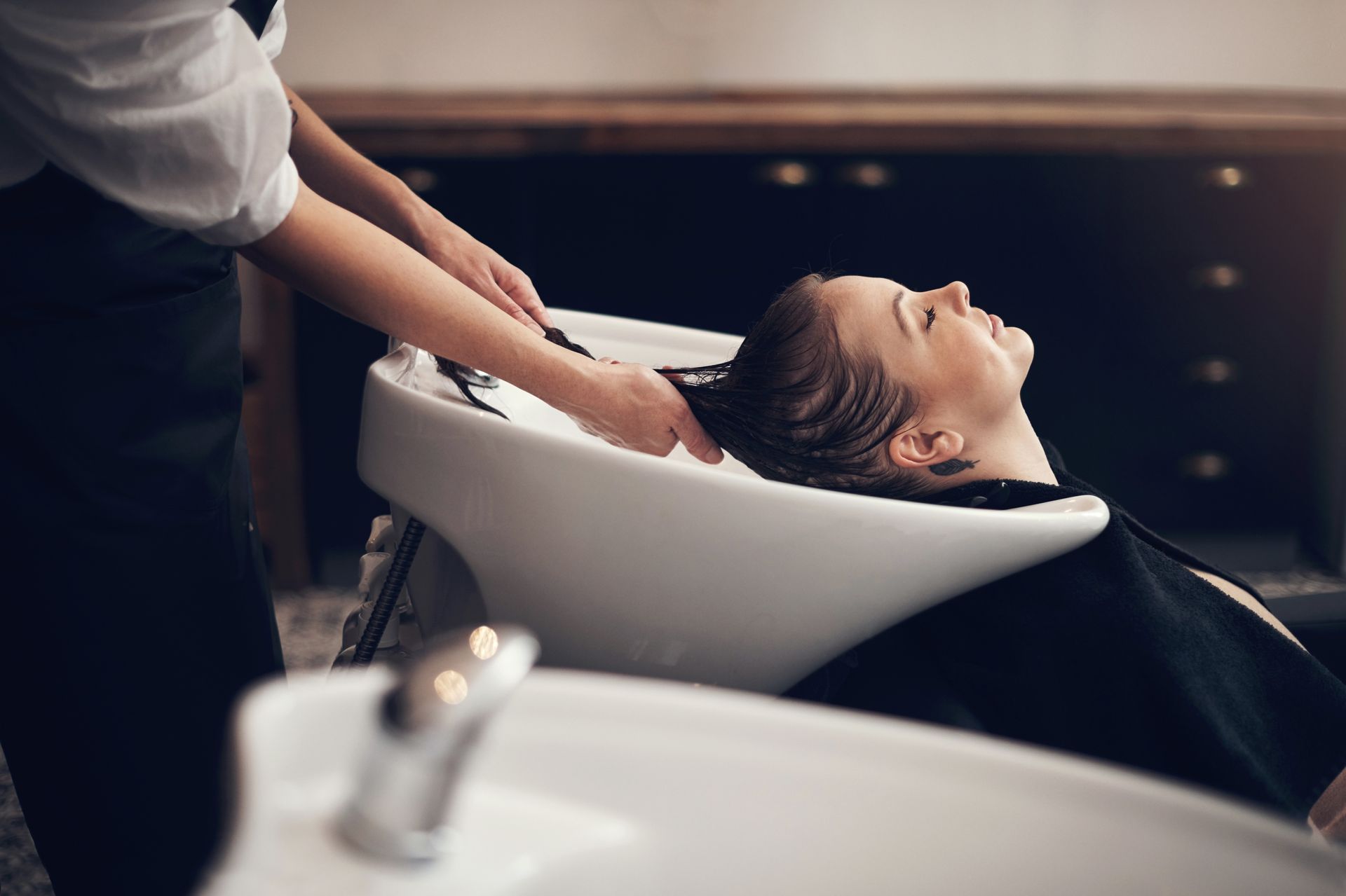 Hairdresser washing a client's hair