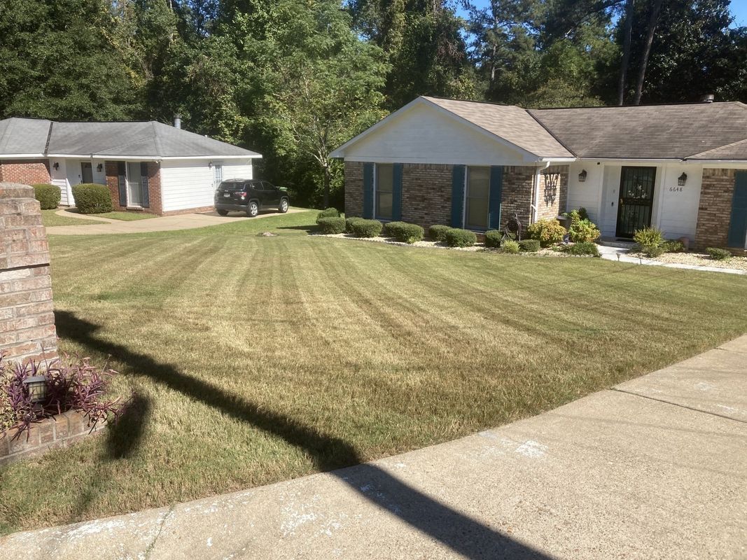 A house with a lush green lawn in front of it.