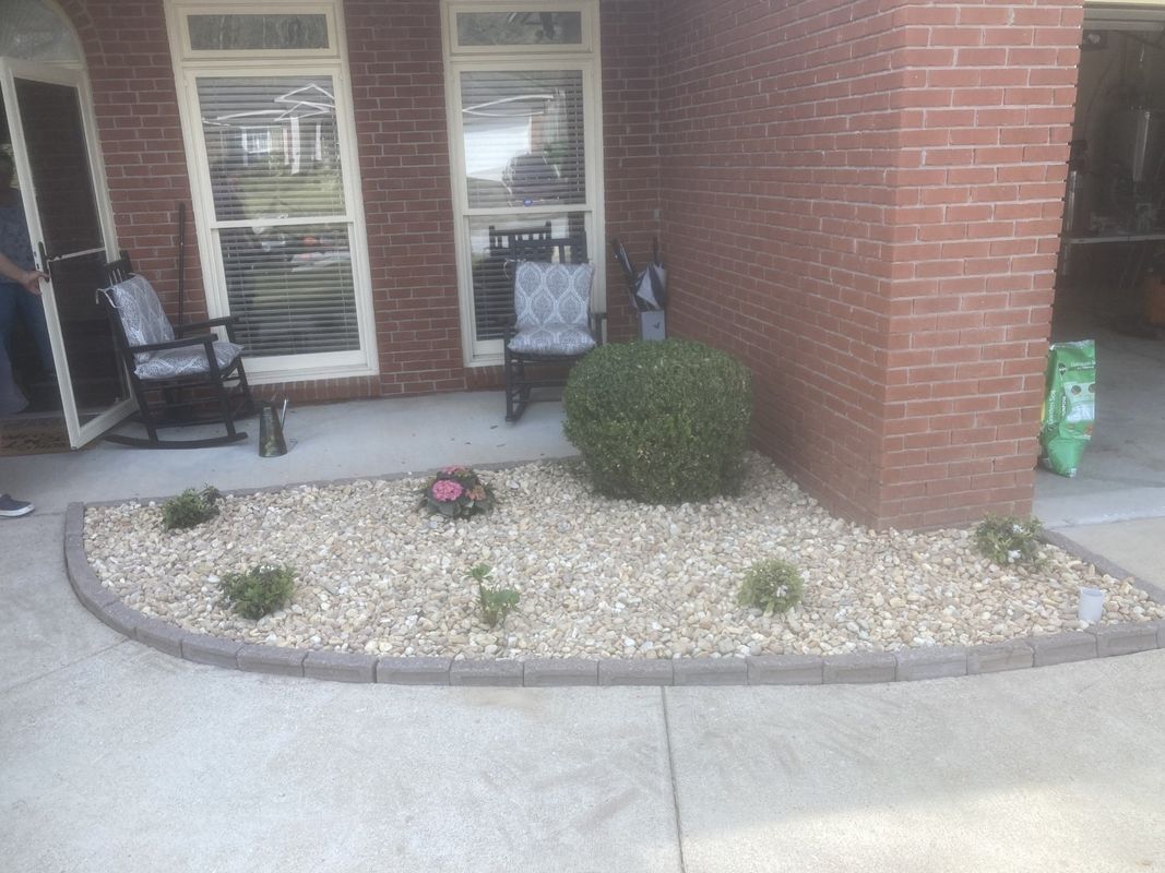 A brick house with a gravel garden in front of it.