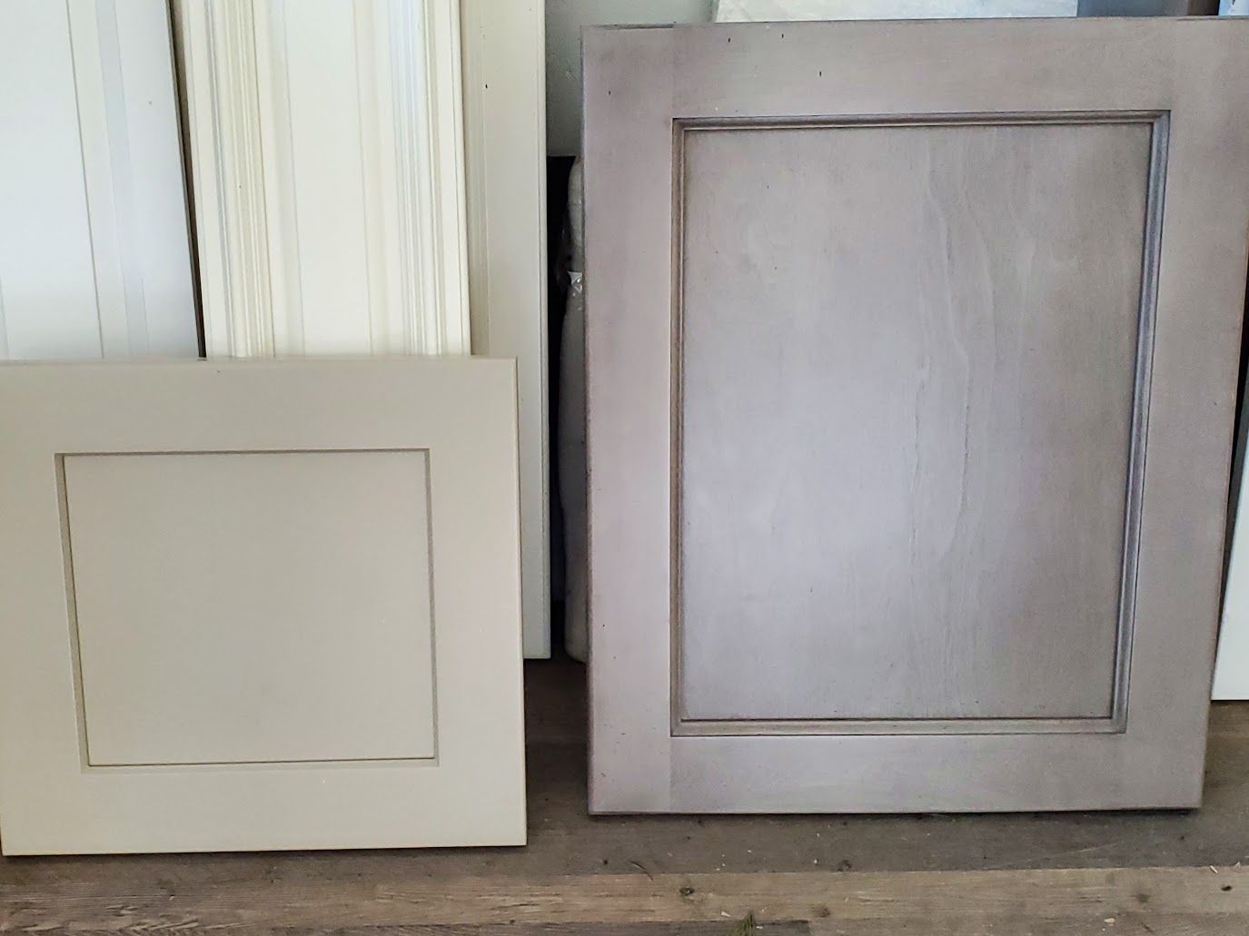 Two square cabinet doors, one small, one large, in beige and gray tones, with distressed edges.
