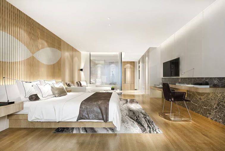Modern bedroom with wood paneling, large bed, desk, and glass-enclosed shower.