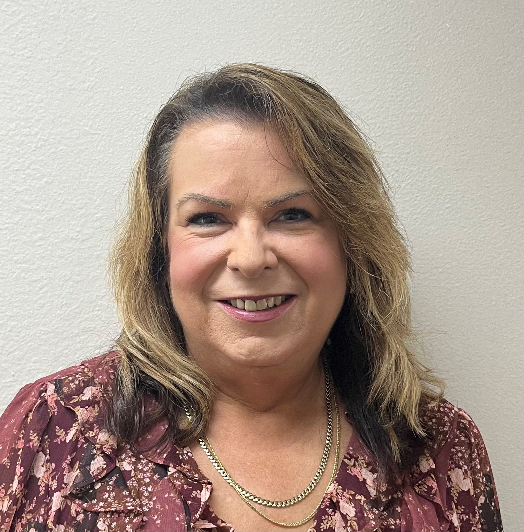 A woman wearing glasses is smiling for the camera.