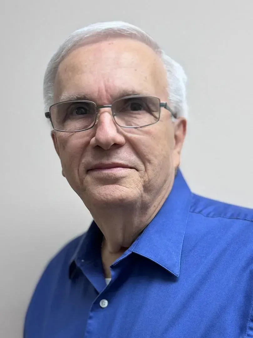 A man wearing glasses is looking at the camera.