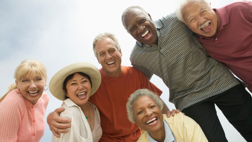 A group of older people are standing next to each other and smiling.