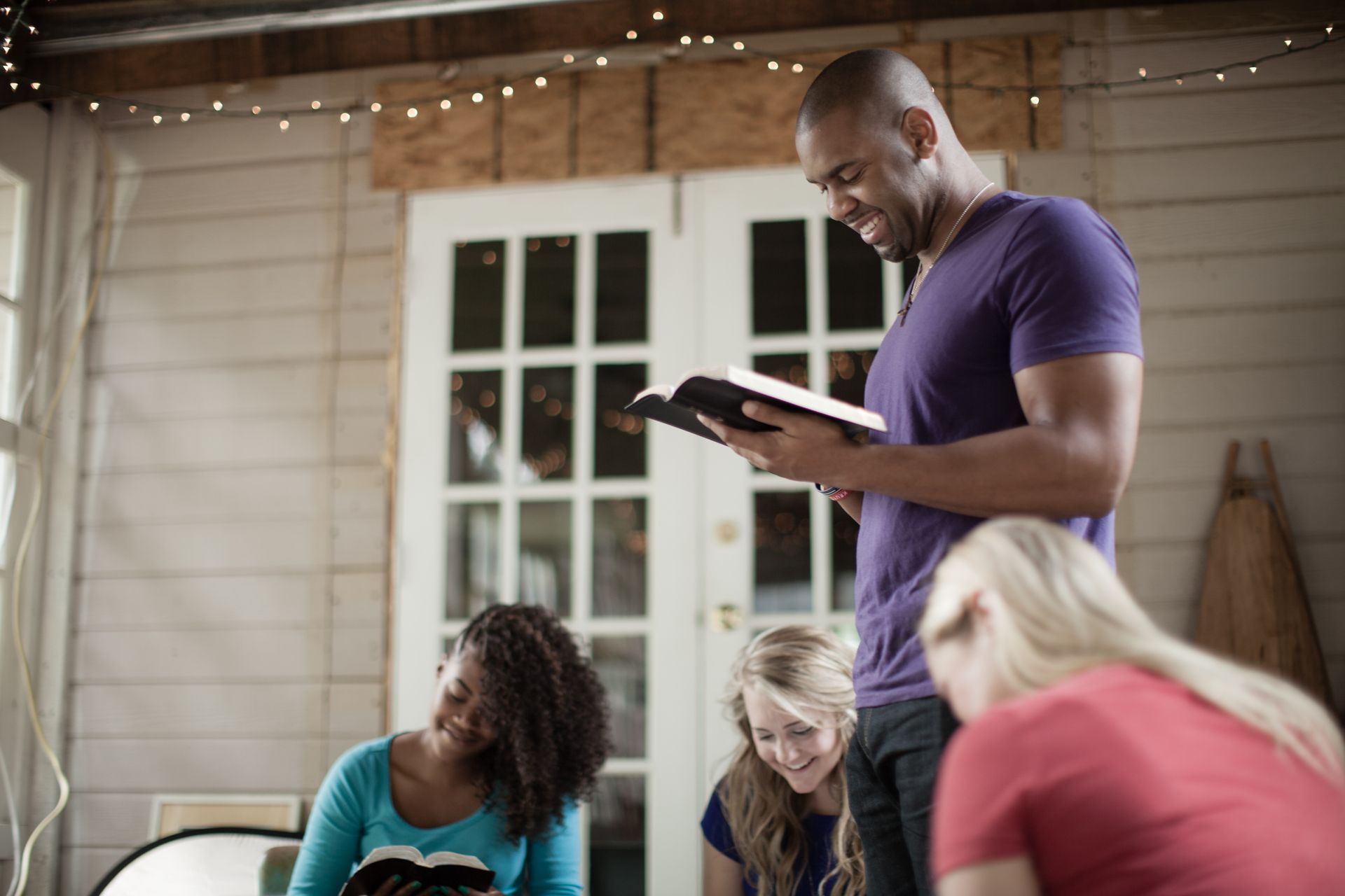A man is reading a bible to a group of people.