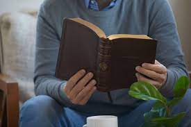 Three men are standing on top of a hill talking to each other.