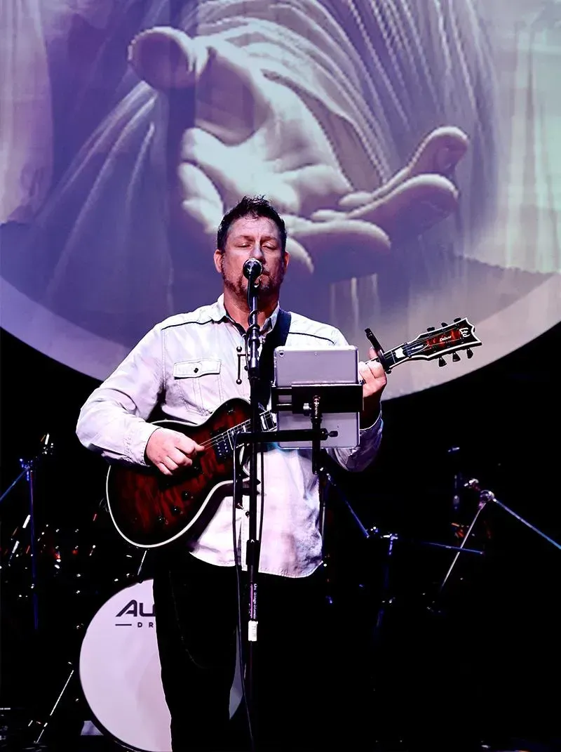 A man is playing a bass guitar