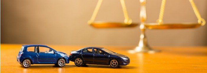 toys cars in front of scales of justice | Jim Mitchell & Jed Davis P.A.