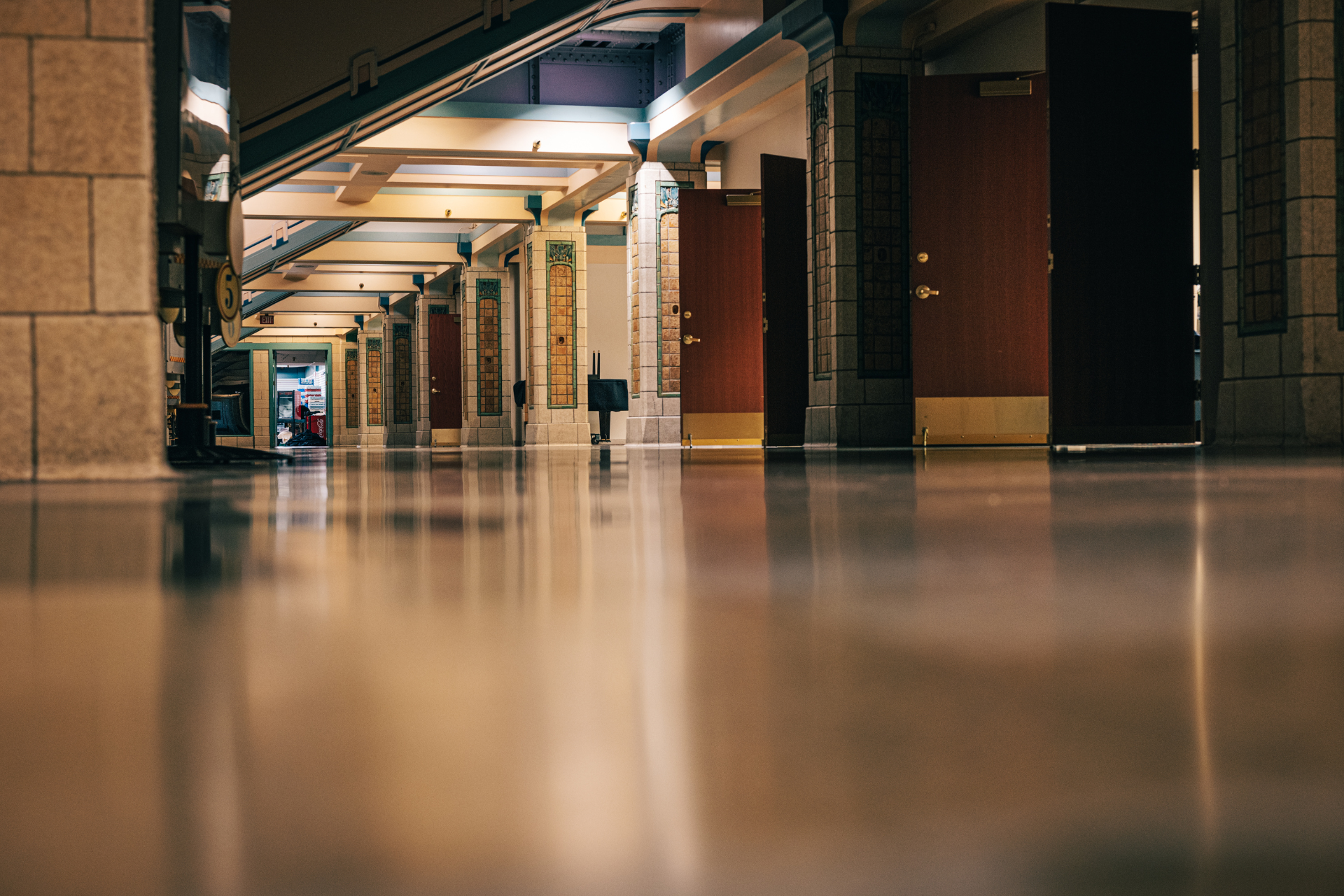 Shiny hallway with dark doors and reflective floor.