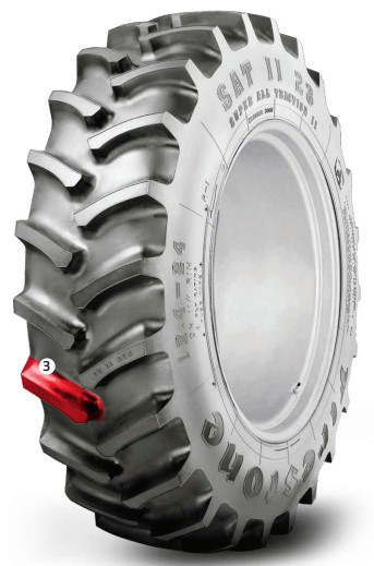 Neumático para tractor agrícola con banda de rodadura gruesa y vástago de válvula de color rojo.