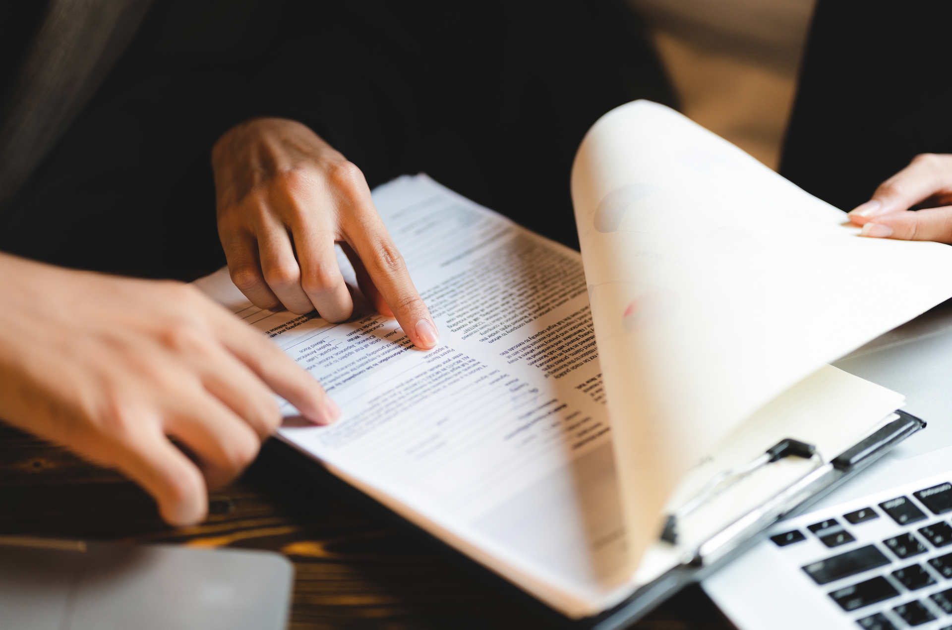 two persons holding documents