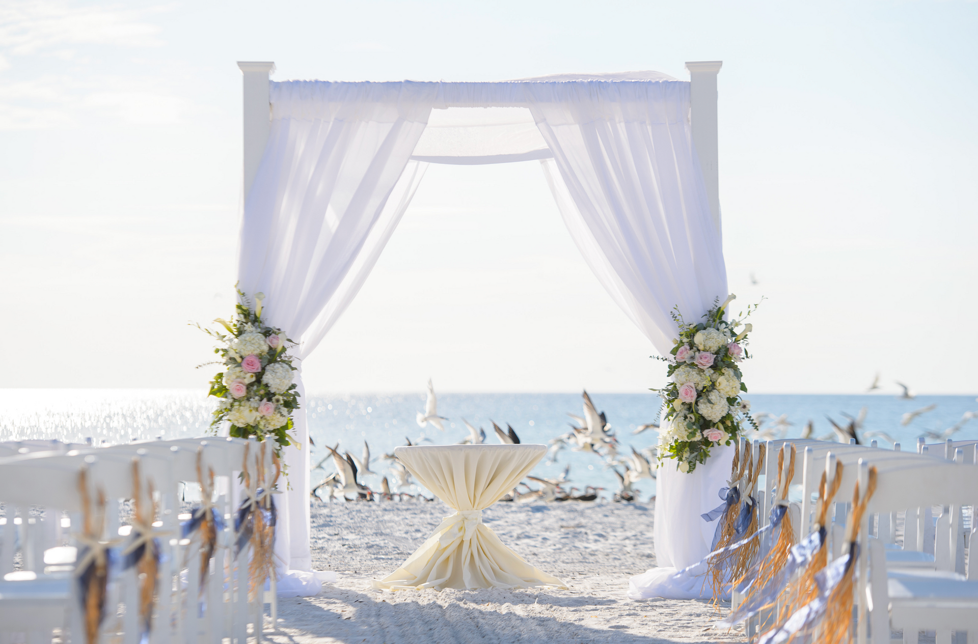 A wedding ceremony is taking place on the beach.