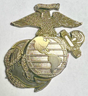 A metallic gold United States Marine Corps Eagle, Globe, and Anchor emblem against a plain background.