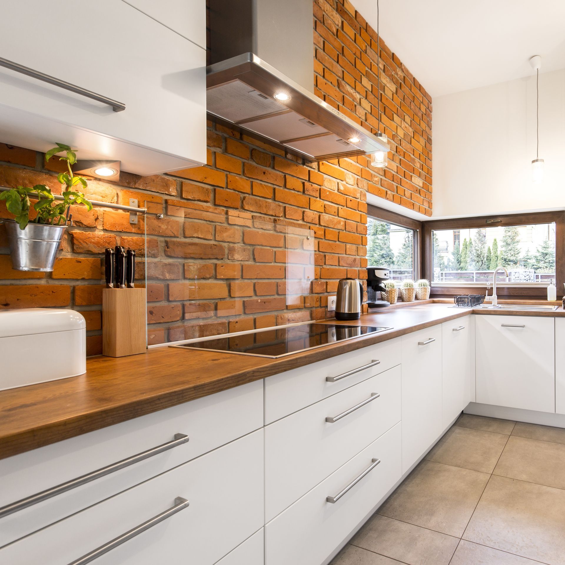 galley kitchen with brick style backsplash and wood look counters