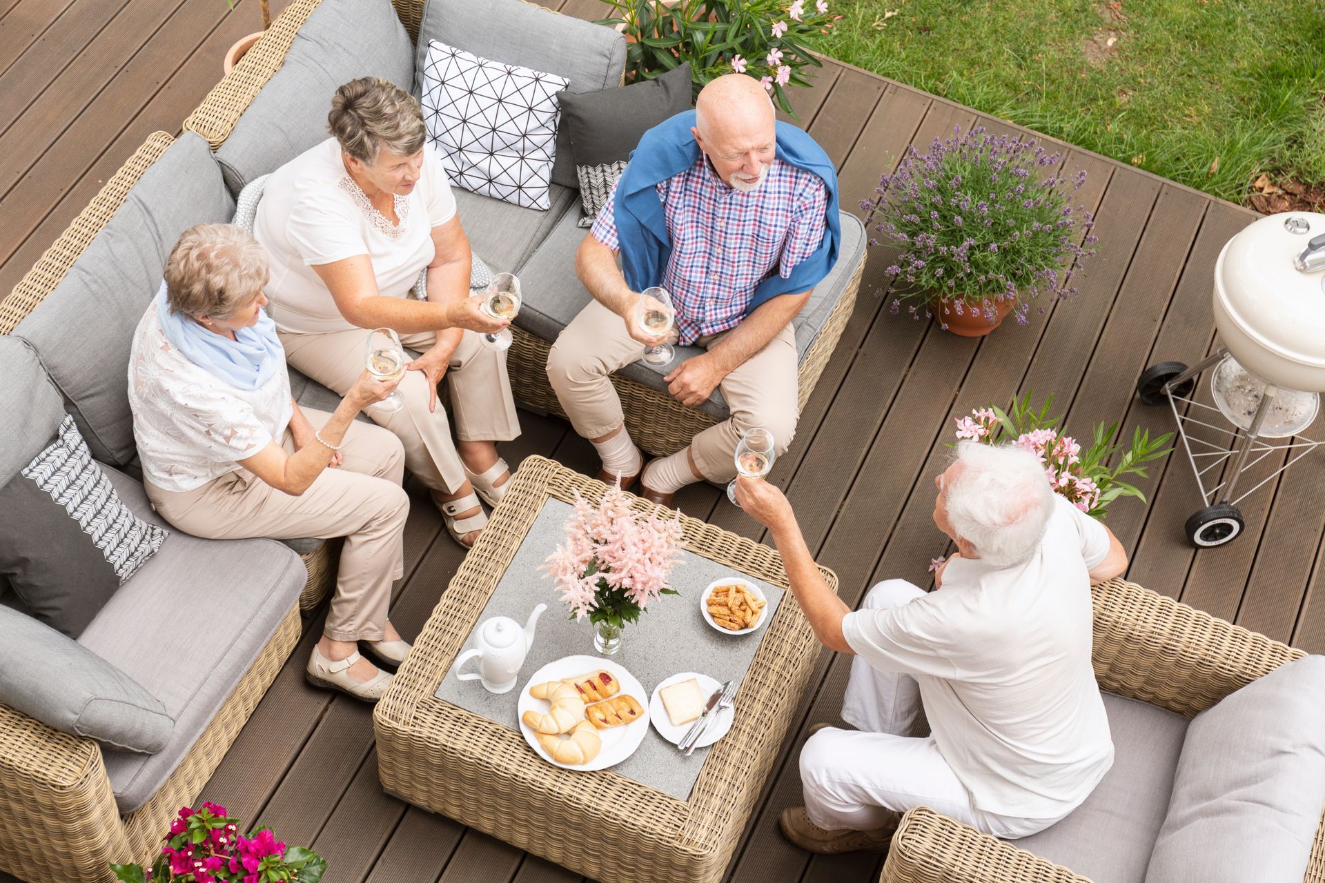 group of retirees sitting on deck furniture with luncheon items