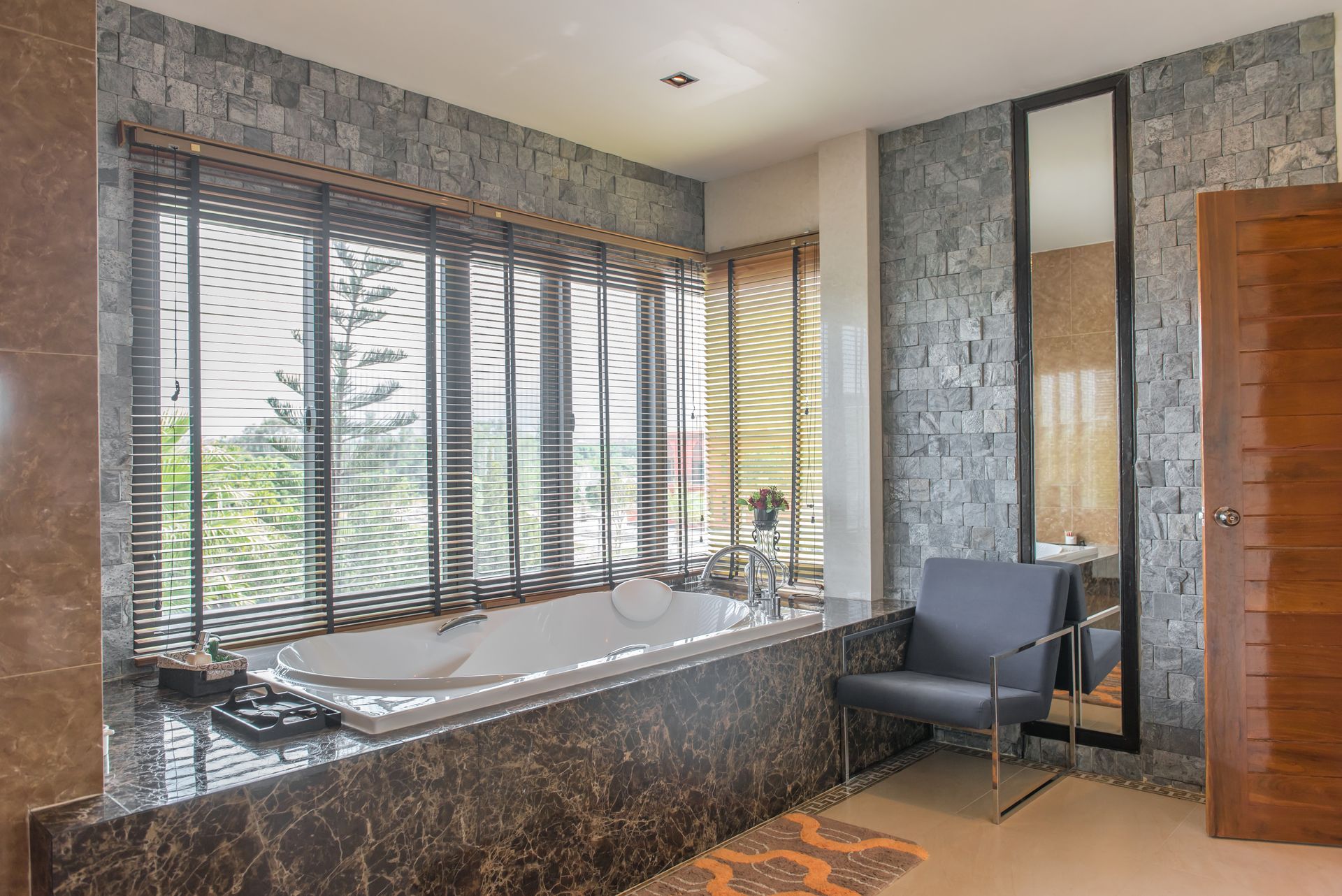 grey stone tiling around jetted tub with surrounding windows