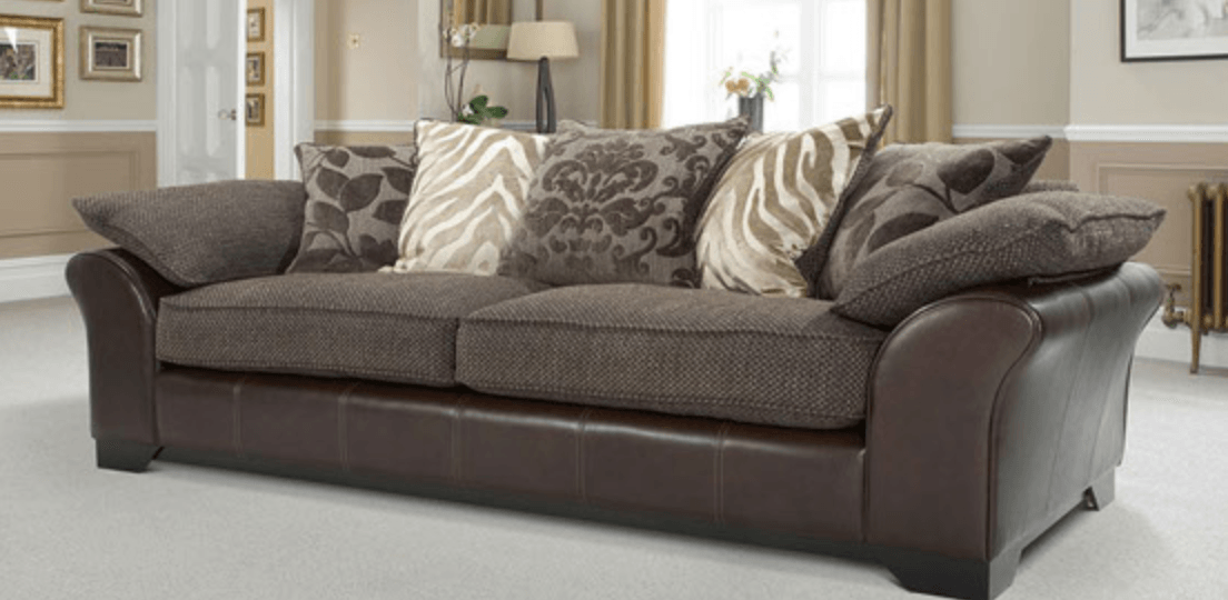 A brown leather couch with pillows in a living room