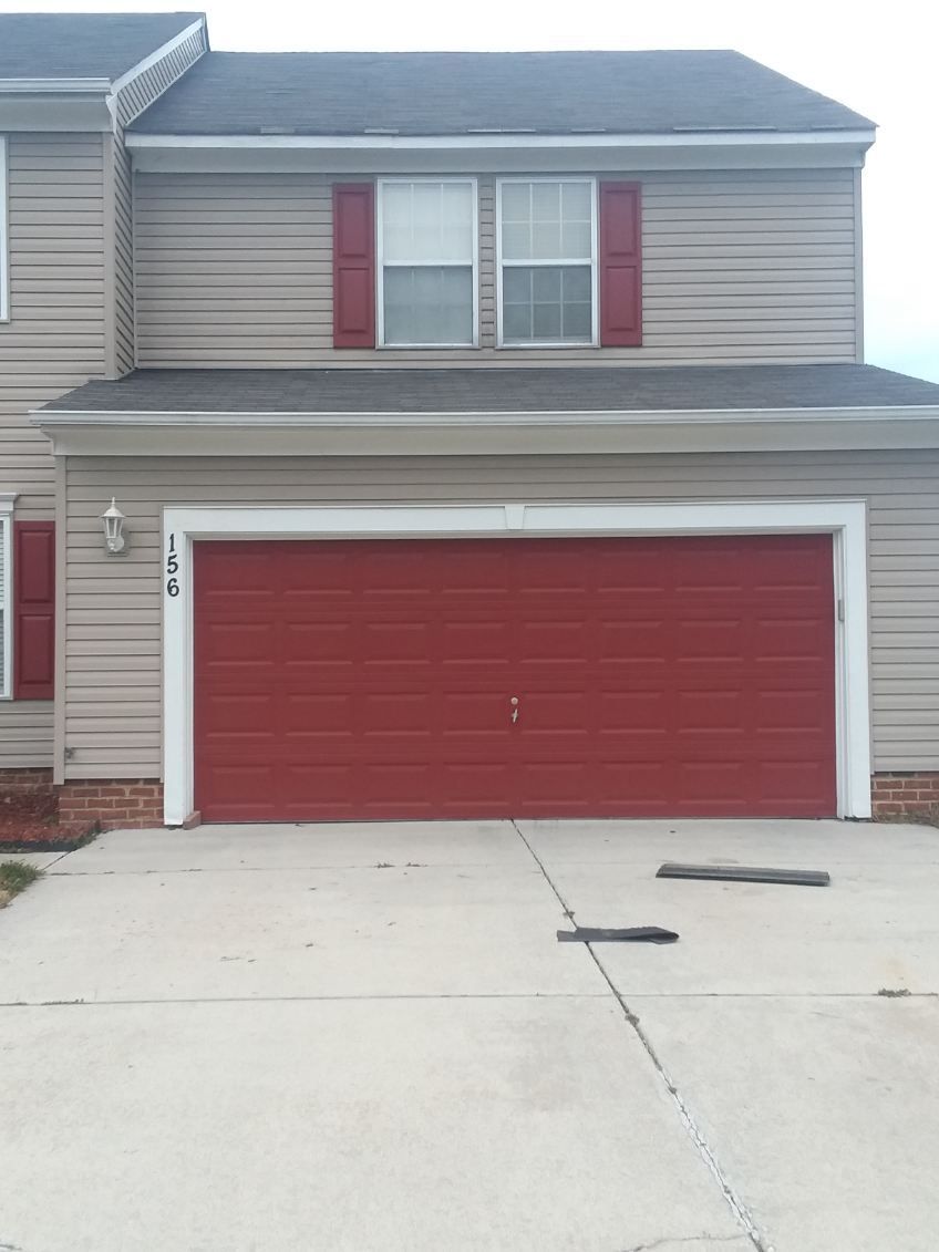 Person using a power drill to install or repair a white window.