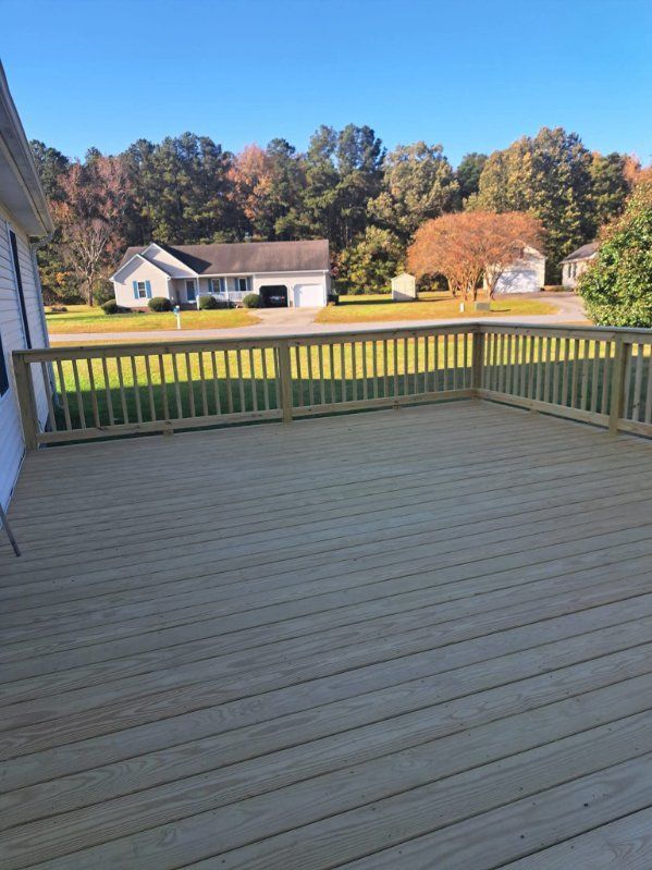 Construction worker on scaffolding, working near a house's roof edge on a sunny day.