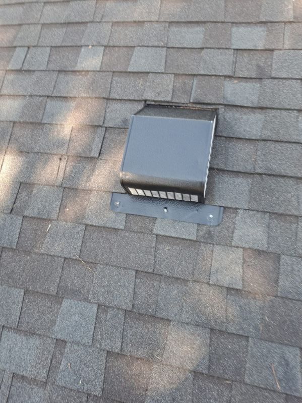 Black roof vent on a gray shingle roof.
