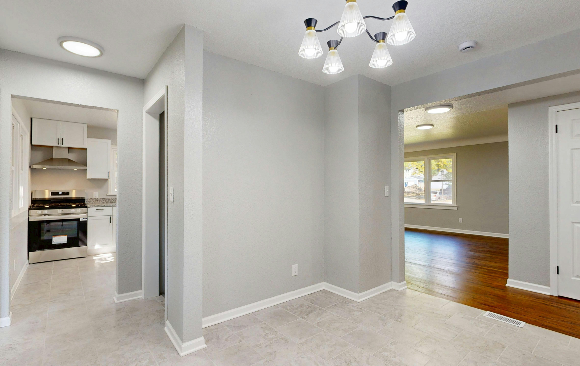 Interior view of a dining area with a view of the kitchen and living room.