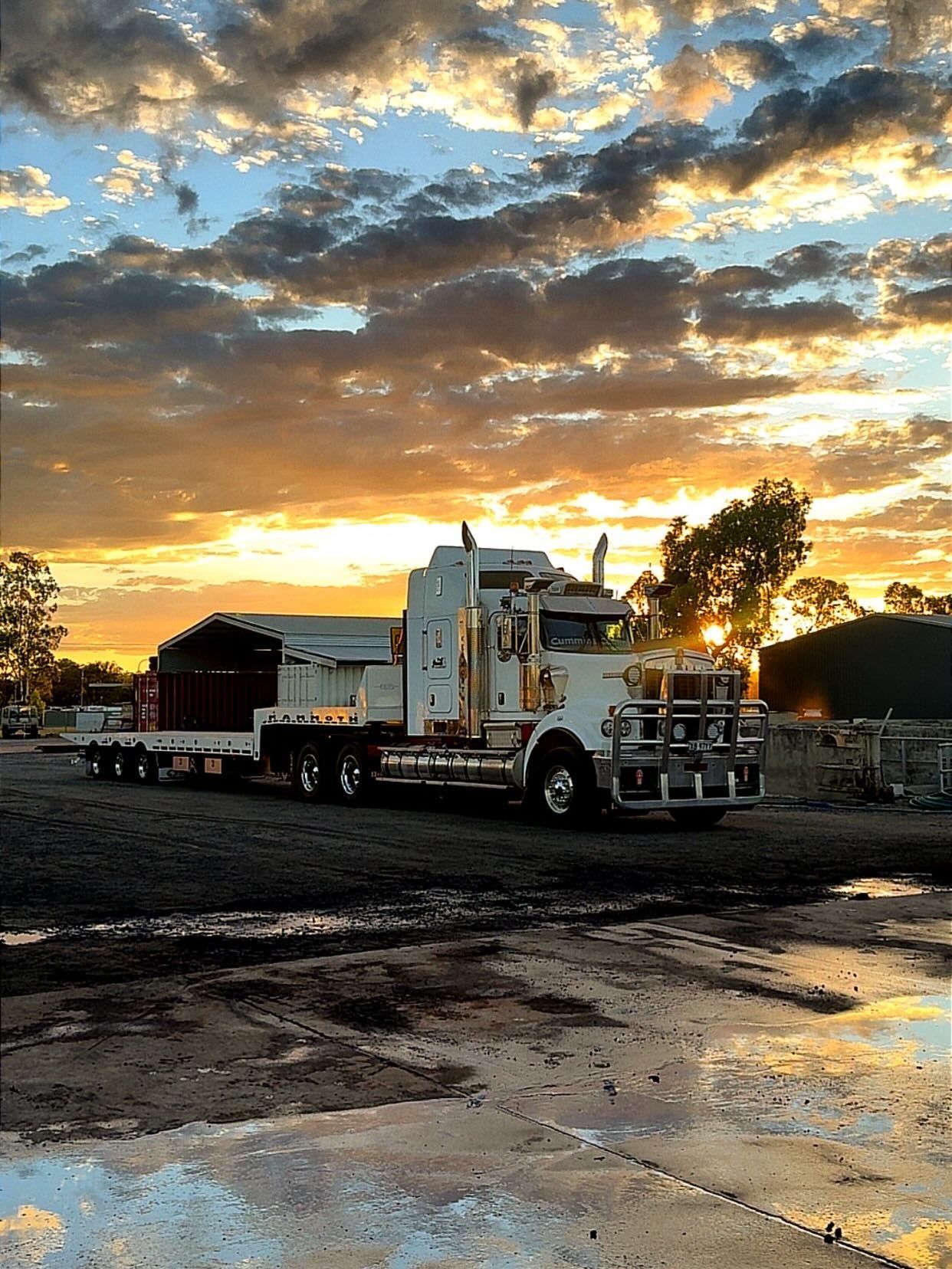 White tow truck on a muddy lot at sunset under a cloudy, golden sky — Full Torque Transport In Parkhurst, QLD 