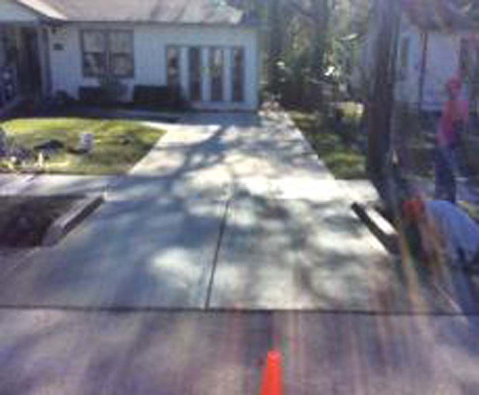 A concrete walkway is being built in front of a house.
