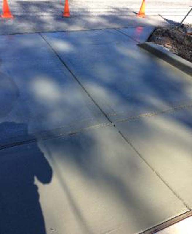 A shadow of a person is cast on a concrete surface.