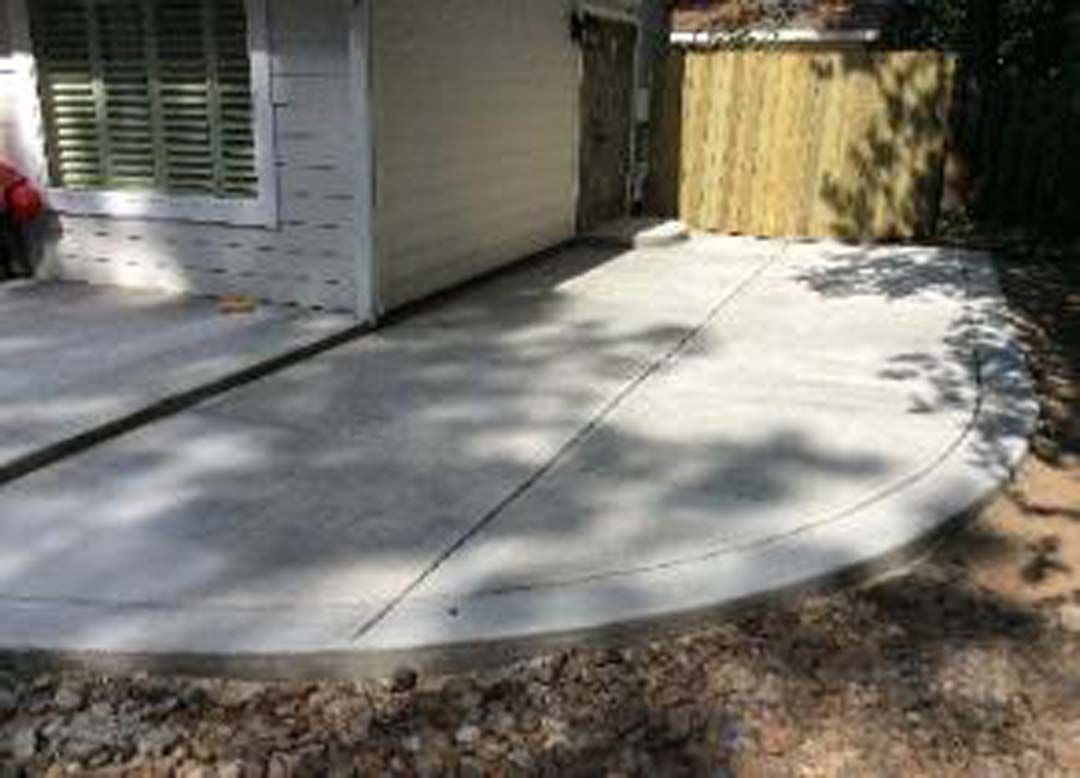 A concrete patio is being built in front of a house.