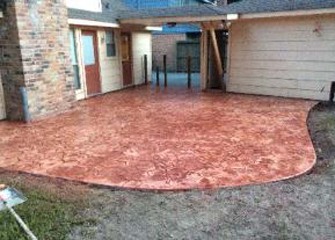 A concrete patio is being installed in front of a house.