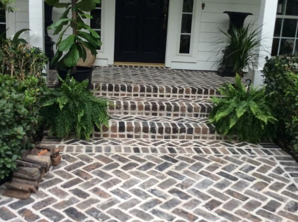 A brick walkway leading to the front door of a house
