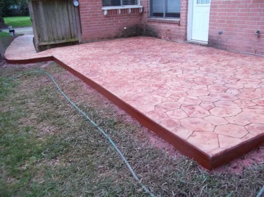A brick house with a concrete patio in front of it.