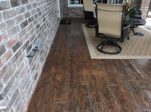 A living room with a wooden floor and a brick wall.
