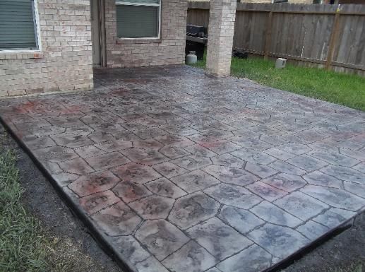 A brick house with a concrete patio in front of it.