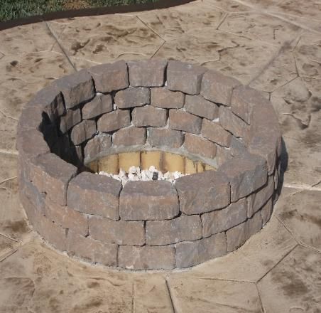A fire pit made of bricks on a concrete surface