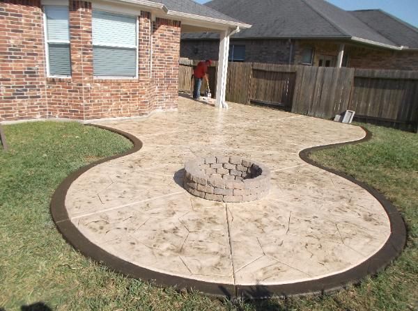 A patio with a fire pit in the middle of it